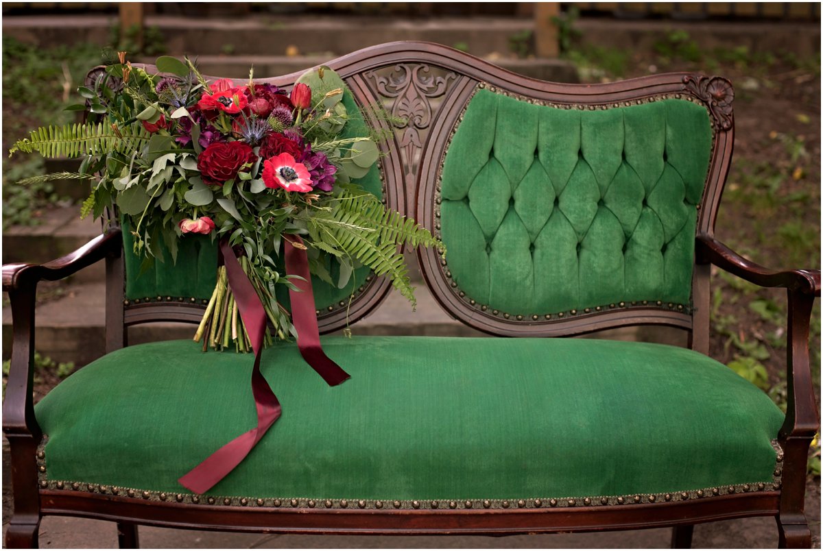 emerald green settee with large bridal bouquet