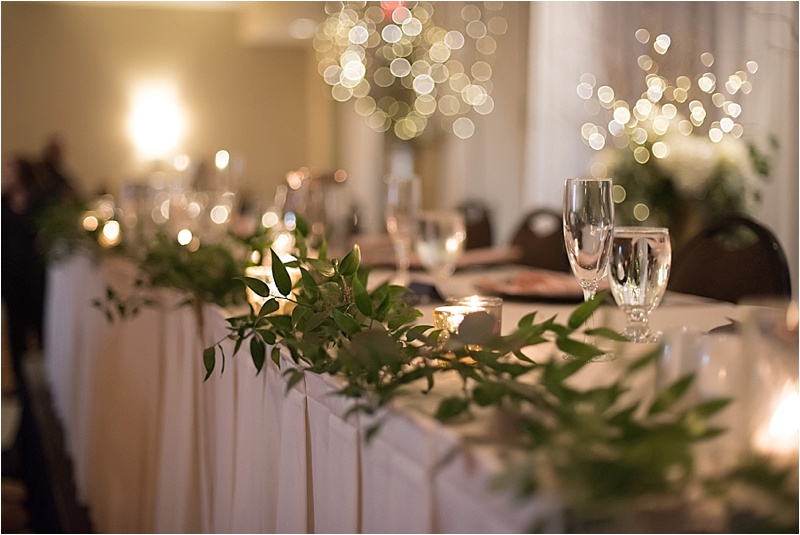 candlelit head table with greenery florals