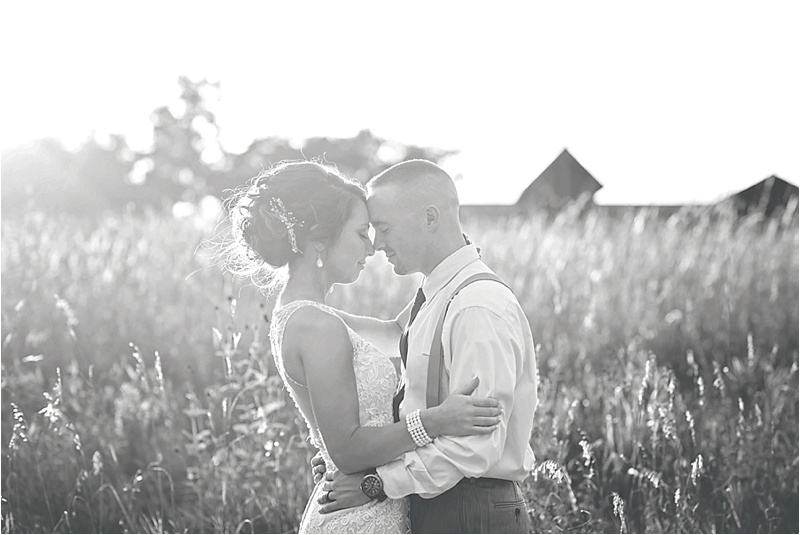 bride and groom in a field on wedding day