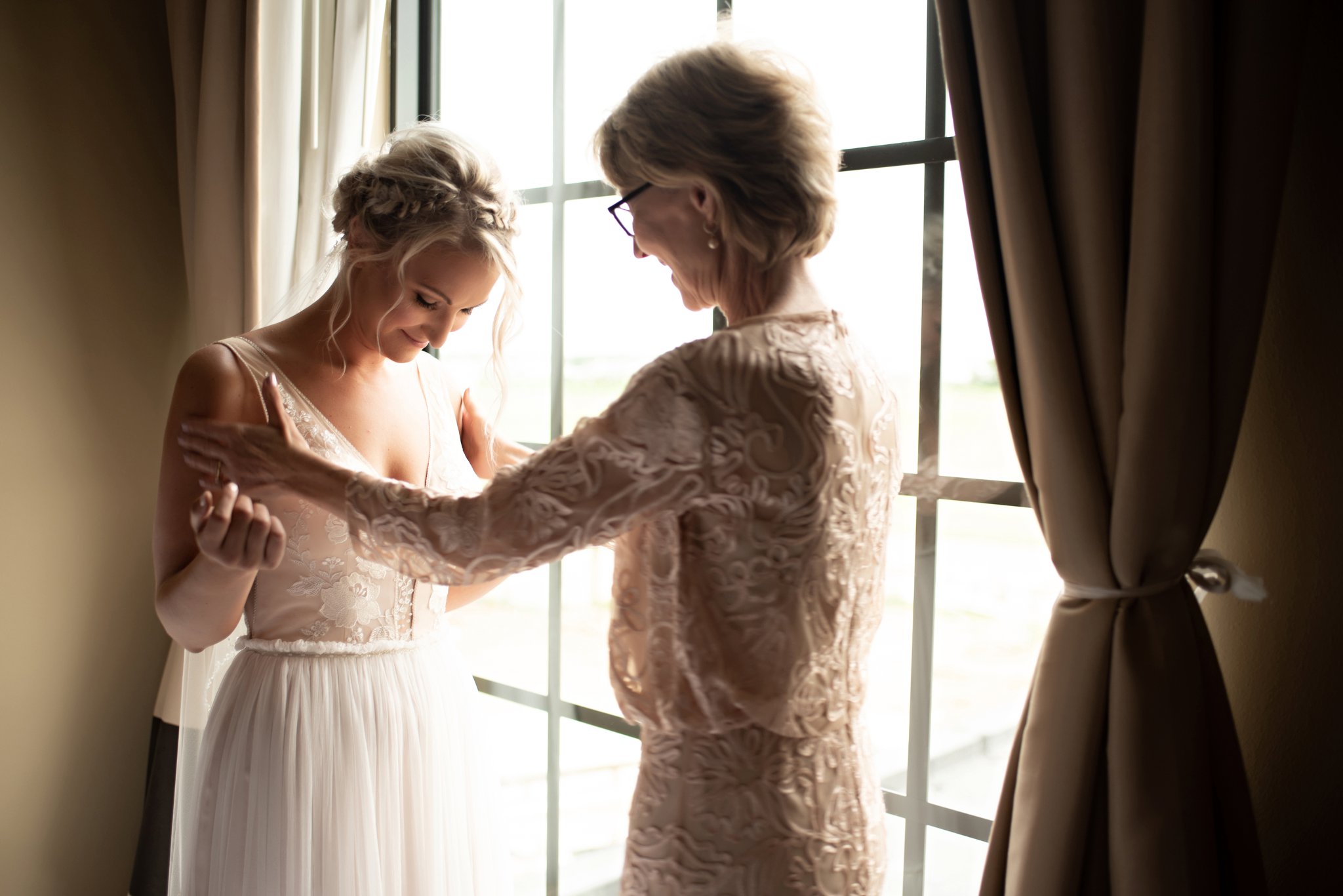 Mom admires the bride in her dress