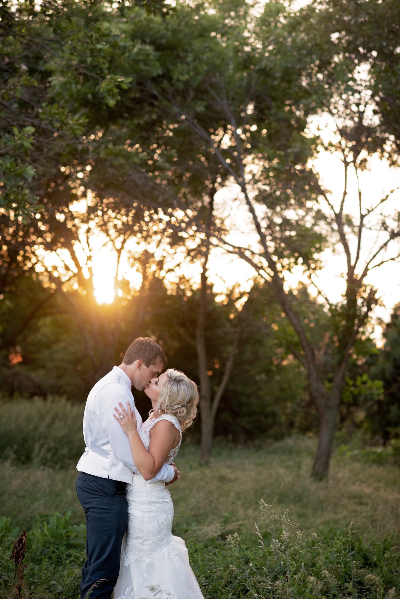 bride and groom kiss at sunset 