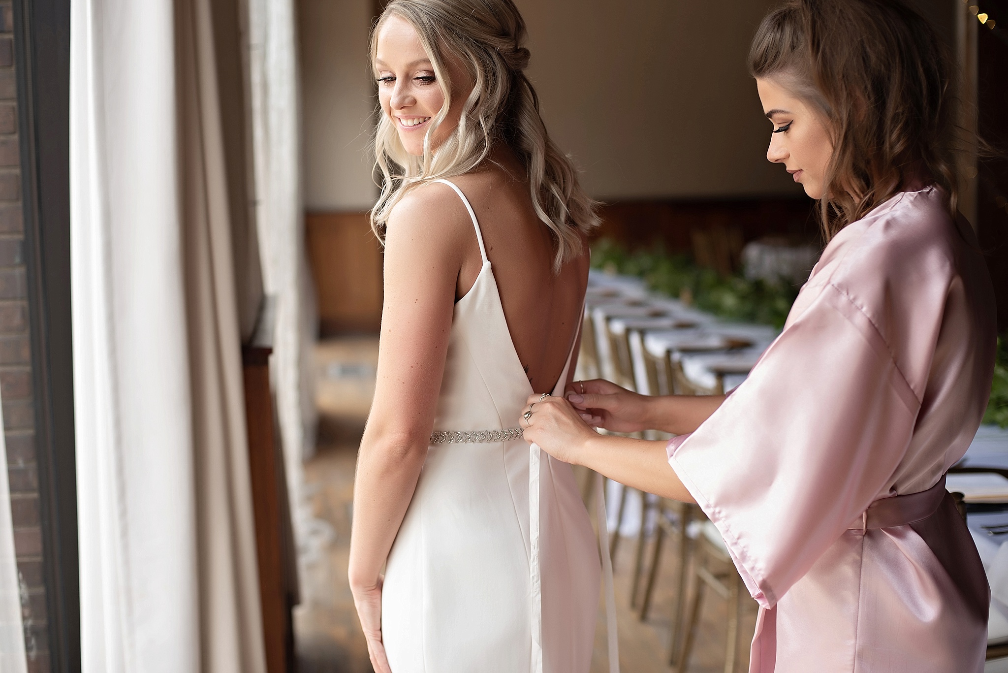 maid of honor helps put bride's details on