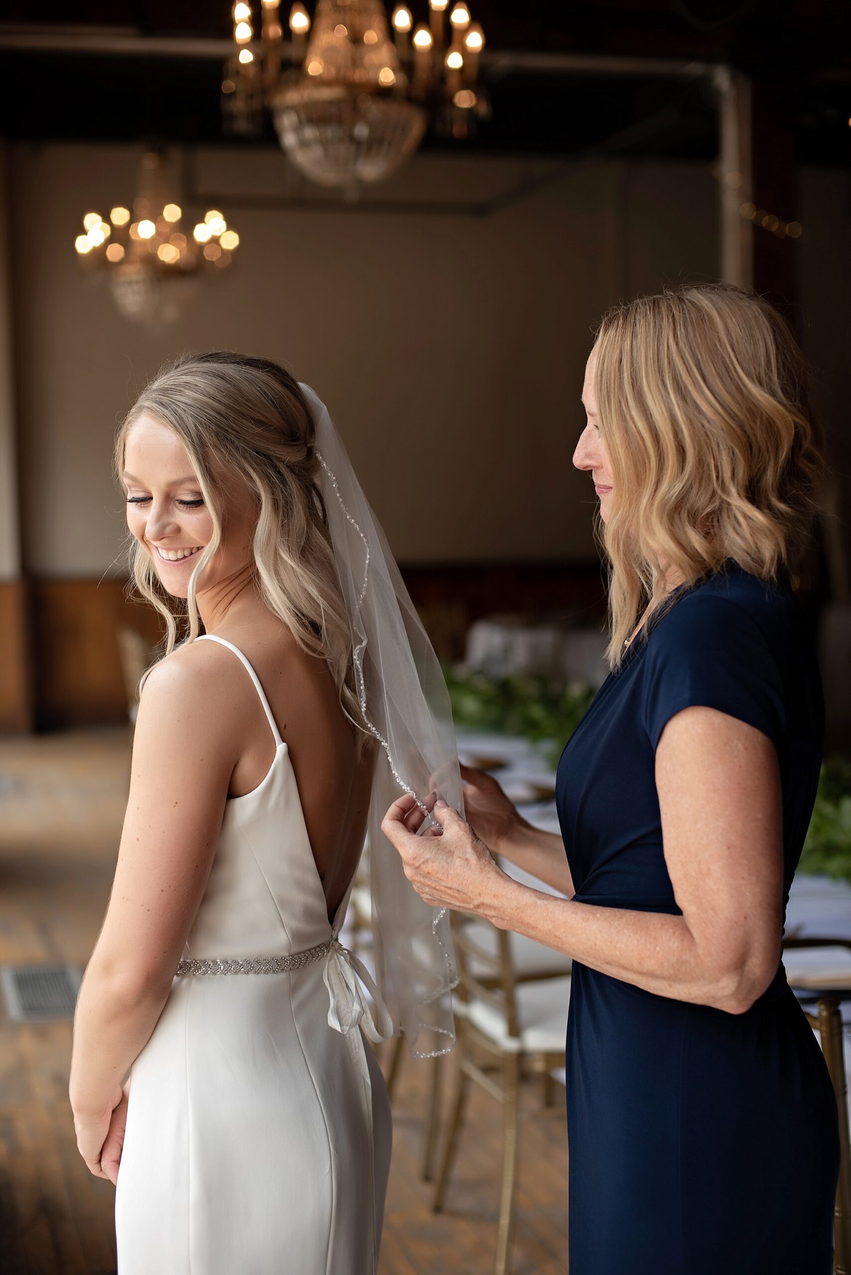 mother of the bride places brides veil with beaded detail