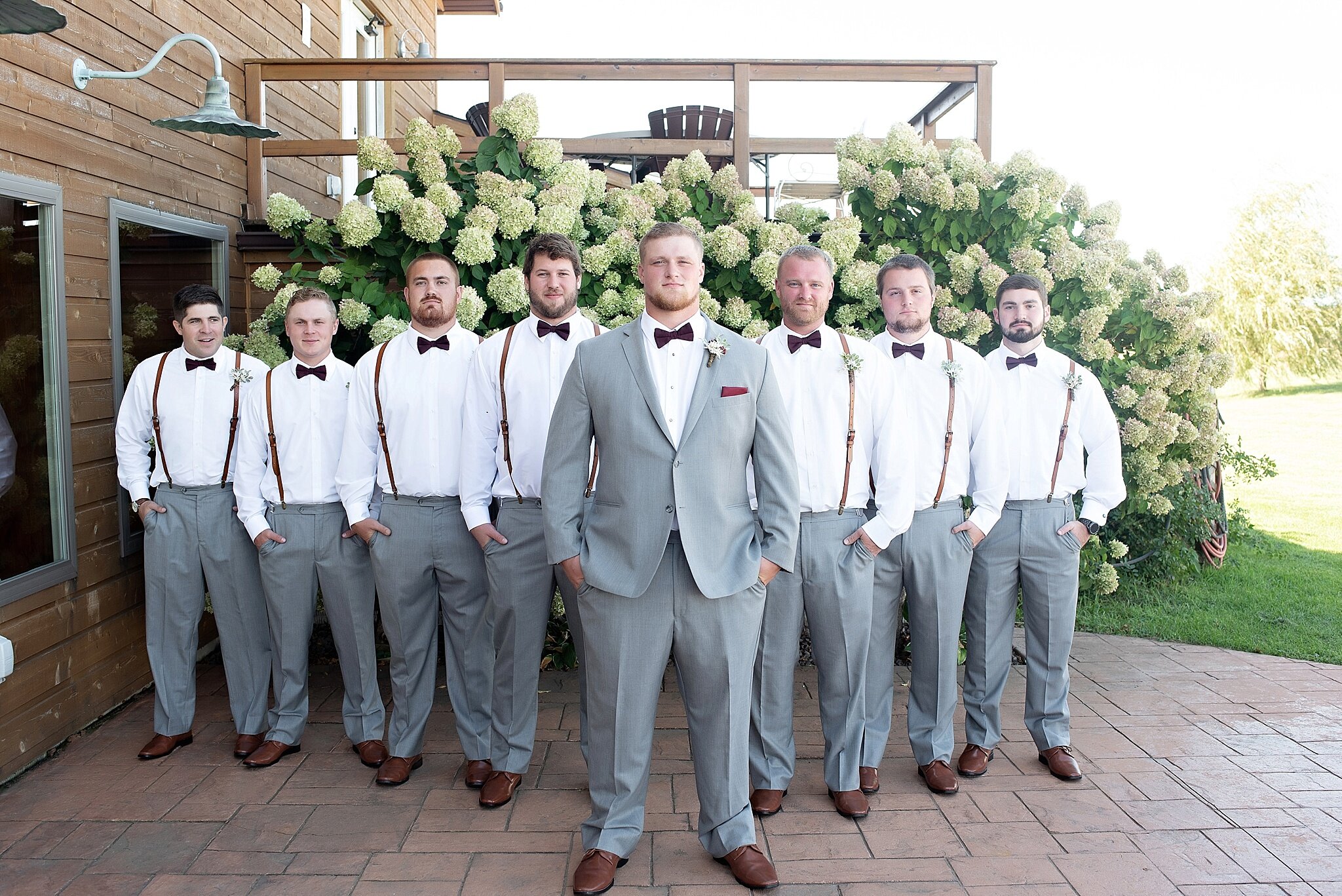 groomsmen gray pants with white button down and brown leather suspenders