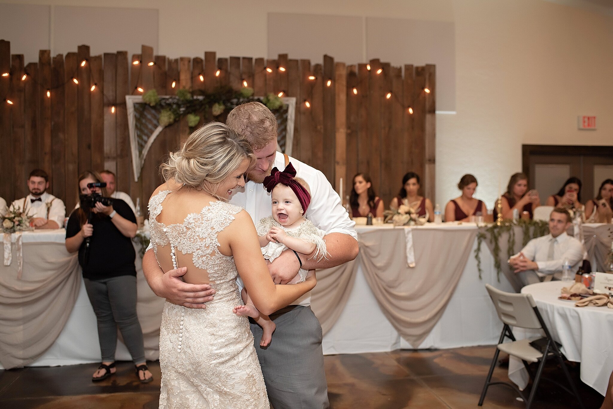 bride and groom dance with daughter at their wedding