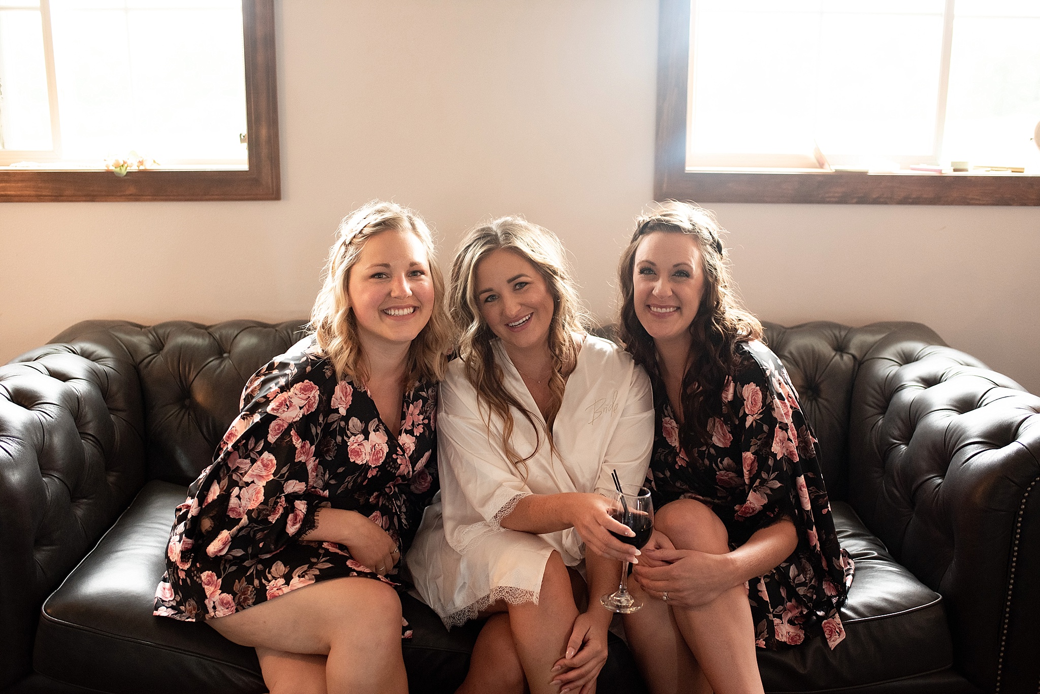 bridesmaids and bride getting ready on a leather couch